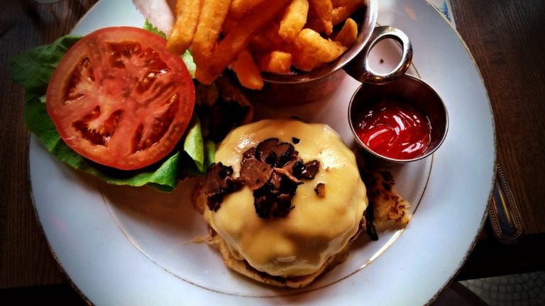Onde comer em New York: foto de um hamburguer com muito queijo derretido e trufa ralada por cima.