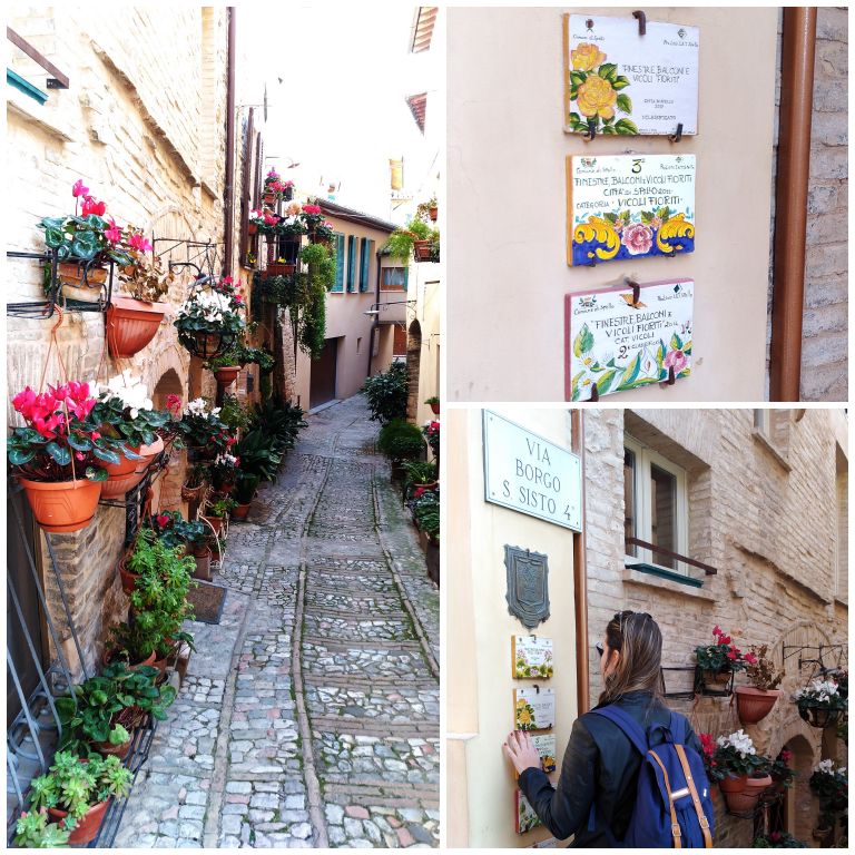 Sacadas e ruas floridas em Spello. Nas paredes, as placas das últimas premiações em uma das ruas mais premiadas.