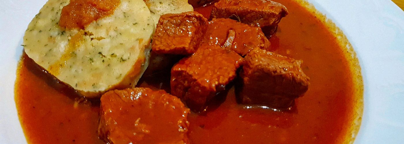 Prato de carne ensopada com knodel. Cores muito vivas. Onde comer em Bregenz: Pfänderdohle Gasthaus: Gulasch com knödel