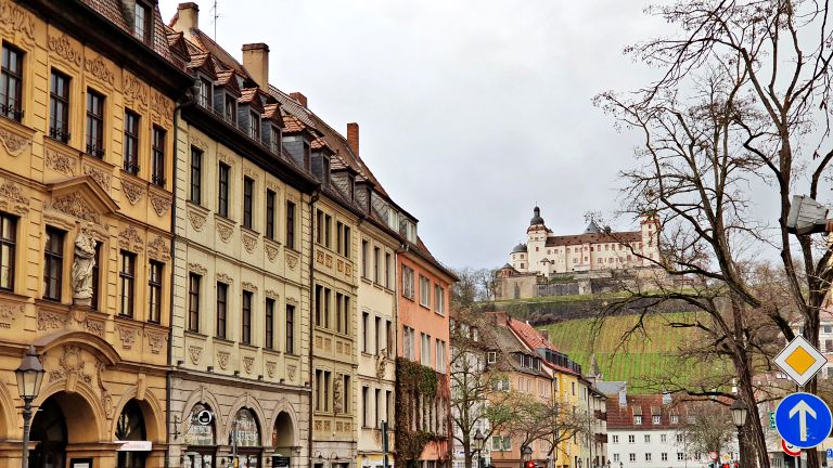 Fachadas das casas no centro histórico de Würzburg com a Fortaleza "Festung Marienberg" ao fundo | Onde ficar em Würzburg