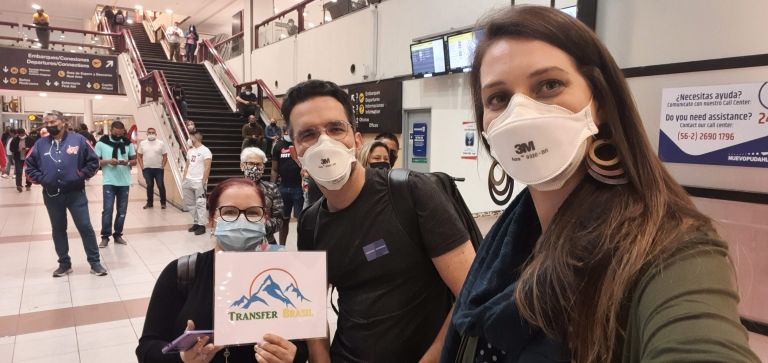 Fátima com a plaquinha da Transfer Brasil no aeroporto de Santiago
