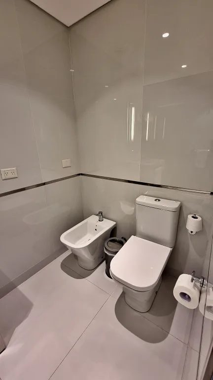 Onde ficar em La Plata: Conheça Dazzler by Wyndham La Plata 20 Área do banheiro da suíte do Dazzler by Wyndham La Plata com vaso sanitário e bidê, com design moderno e minimalista.