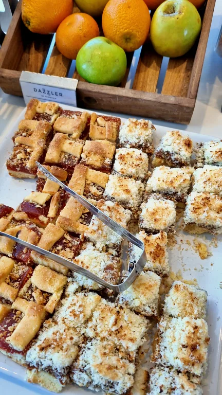 Onde ficar em La Plata: Conheça Dazzler by Wyndham La Plata 36 Bandeja com facturas, doces de padaria, além de uma cesta com frutas frescas, no café da manhã do hotel Dazzler by Wyndham La Plata.